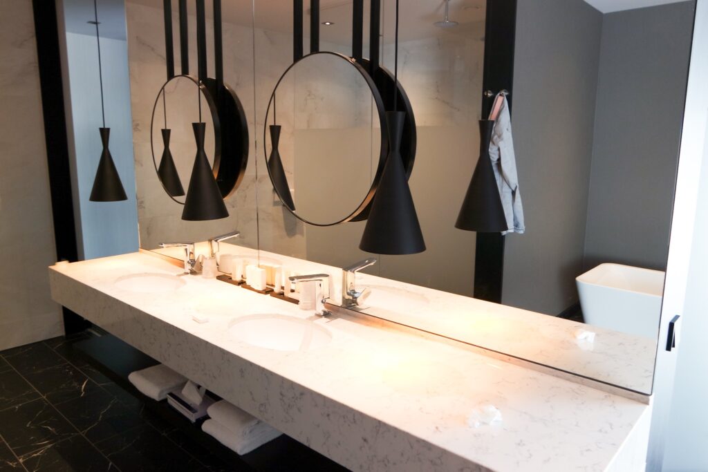 A view of a luxurious bathroom with circular mirrors, two sinks, and a large countertop.