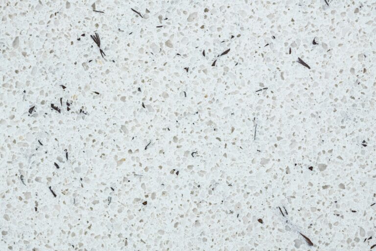 A closeup of a white quartz countertop flecked with black and gray.