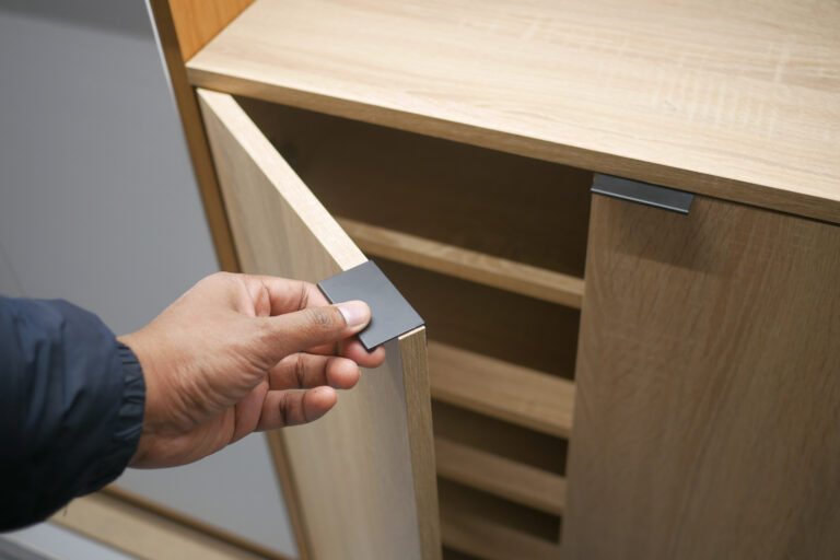 man's hand open drawer wooden in cabinet.