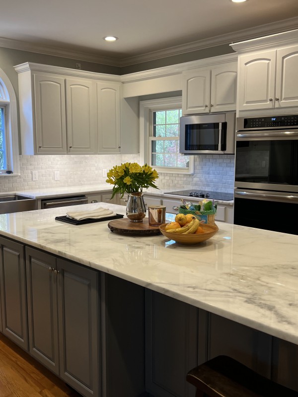 Stylish gourmet kitchen featuring gray cabinetry, a spacious white island, and stainless steel appliances, perfect for showcasing comprehensive kitchen remodeling services.